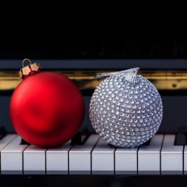 Event-Holiday-Concert-375x375–4 Ornaments resting on piano keys.